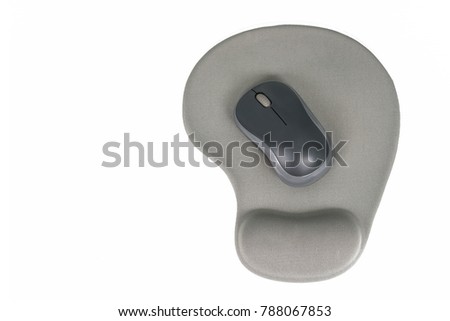 Black wireless mouse placed on gray mouse pad with gel wrist support on white background.
