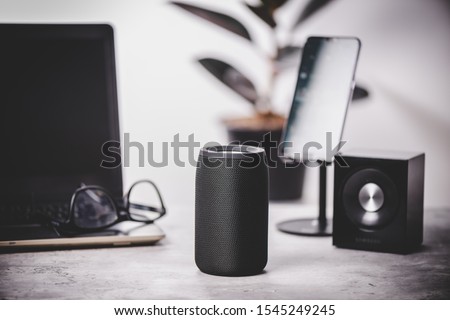 Black wireless portable bluetooth speaker for music listening. Voice assistant speaker at home.