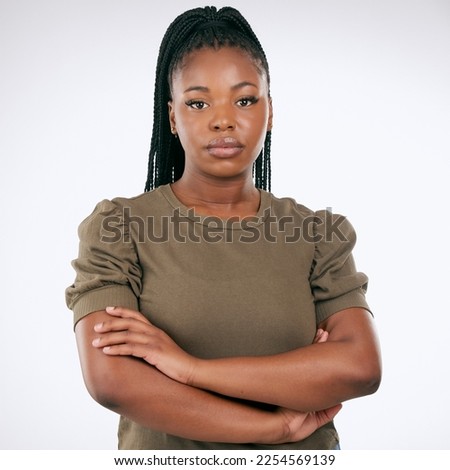 Black woman, arms crossed and standing isolated on gray background for confident profile or empowerment. Portrait of African American female model with serious face for leadership or management