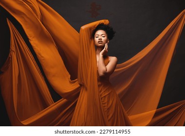 Black woman, art and fashion, flowing fabric on dark background with beauty and aesthetic movement. Silk, fantasy and artistic portrait of serious African model in creative designer dress in studio. - Powered by Shutterstock