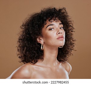 Black woman, beauty and skincare face portrait for natural afro, facial or hair care cosmetics. Healthy, beautiful and assertive model with curly hair shine and texture in brown studio background. - Powered by Shutterstock