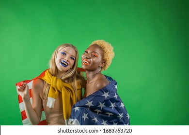 Black woman with blond american blond woman hugging holding american flag and smiling, concept of independent women in america and independence day of america - Powered by Shutterstock