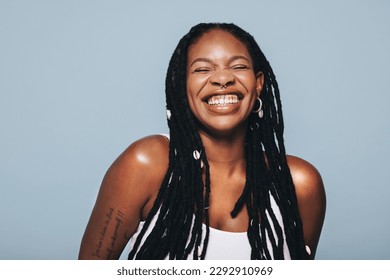 Black woman with body piercings smiling in a studio. Happy young woman feeling confident in herself.