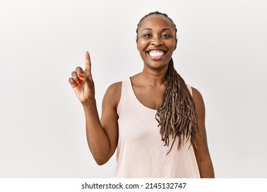 Black woman with braids standing over isolated background showing and pointing up with finger number one while smiling confident and happy. 