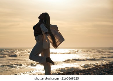 Black Woman With Braids Walking Along The Beach Barefoot, Vacationing In The Sunset. Horizontal Photo