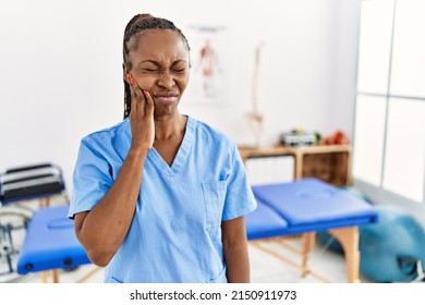 Black Woman With Braids Working At Pain Recovery Clinic Touching Mouth With Hand With Painful Expression Because Of Toothache Or Dental Illness On Teeth. Dentist 