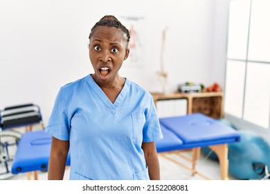 Black woman with braids working at pain recovery clinic in shock face, looking skeptical and sarcastic, surprised with open mouth  - Shutterstock ID 2152208081