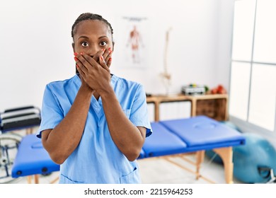 Black Woman With Braids Working At Pain Recovery Clinic Shocked Covering Mouth With Hands For Mistake. Secret Concept. 