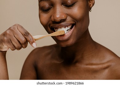 Black Woman Brushing Her Teeth With A Wooden Toothbrush