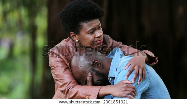 Black woman\
consoling crying depressed\
man.