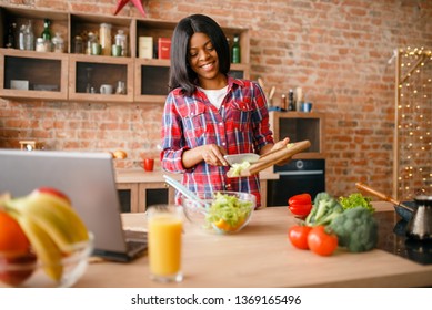 Black Woman Cooking Salad On The Kitchen