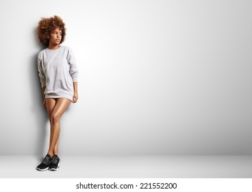 black woman with curly hair wearing sweatshirt like a dress - Powered by Shutterstock