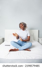 Black Woman Dancing With Headphones On Her Bed At Home. Lifestyle