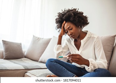 Black Woman Desperate After Reading Pregnancy Test Result. Disappointed African-american Girl Getting Unexpected Result From Pregnancy Test. Shot Of A Young Woman Taking A Pregnancy Test At Home