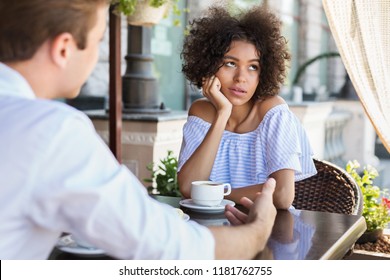 Black Woman Disinterested With Blind Date At Outdoor Cafe