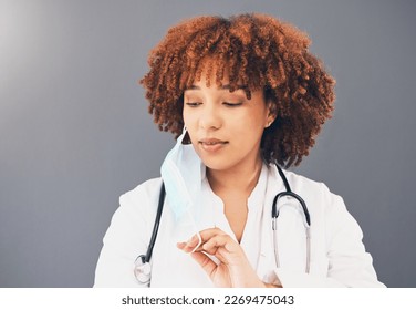 Black woman, doctor and covid 19, remove face mask and health, end of pandemic and protection on studio background. Serious, mockup space with healthcare, safety and post coronavirus with female - Powered by Shutterstock