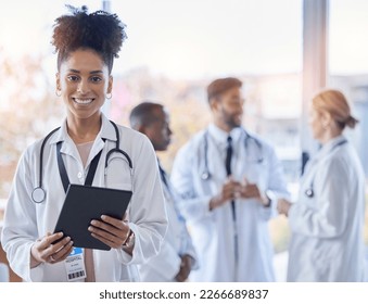 Black woman, doctor portrait and tablet with medical team in hospital ready for healthcare work. Wellness, health and medic employee in a clinic feeling happiness and success with blurred background