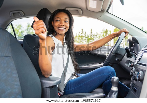 A black woman\
driver seated in her new car