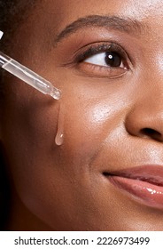 Black woman, dropper and facial skincare cosmetics for beauty, hydration or oil treatment for healthy face. Closeup of African American female applying serum to cheek for skin hydrate, glow or shine