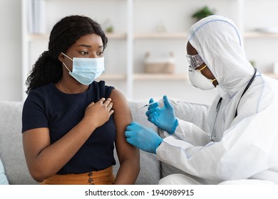 Black woman in face mask getting injection at home - Powered by Shutterstock