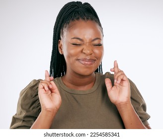 Black woman, fingers crossed and luck for competition, prize or lottery draw against a grey studio background. African American female in hope for bonus, promotion or winning lucky giveaway on mockup - Shutterstock ID 2254585341