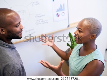 A Black woman gestures in heated discussion with coworker on strategy plan