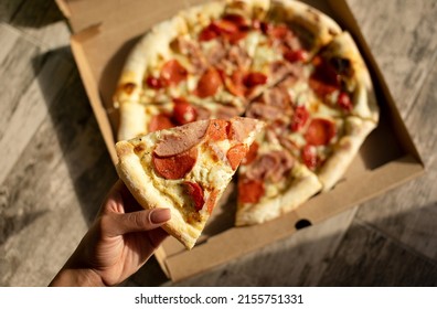 Black Woman Hand Holding Slice Pizza.