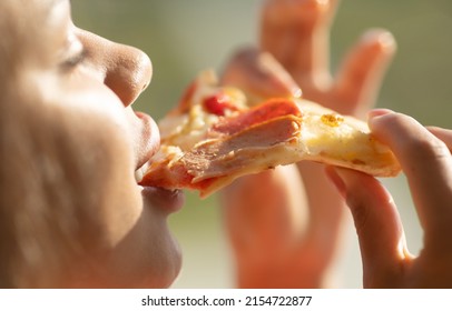 Black Woman Hand Takes A Slice Of Meat Pizza. Young Woman Eating Pizza Outdoor In Street.