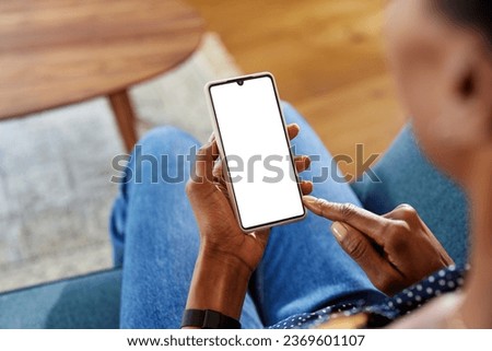 Black woman hands using smartphone while relaxing at home. Close up of african american woman using phone with empty screen. Mobile phone in hands with blank screen ready for your website.
