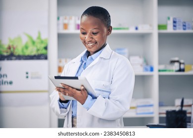 Black woman, happy pharmacist and tablet for healthcare, telehealth and research in pharmacy, drugstore or shop. Medical professional, technology and African doctor with wellness email for medicine. - Powered by Shutterstock