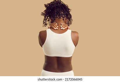 Black Woman Has Neck Pain And Backpain Due To Fibromyalgia, Osteochondrosis, Muscle Spasm. Sad Unhappy Tired Lady Depressed By Troubles, Feeling Physical Or Emotional Discomfort. Back View, Backside