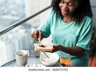 Black Woman Having Breakfast At The Balcony