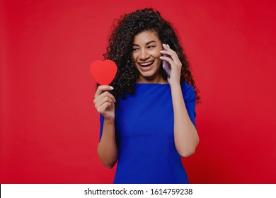 Black Woman With Heart Shaped Valentine Card Talking On The Phone On Red Background