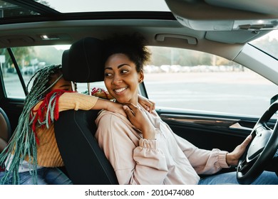 Black Woman And Her Daughter Smiling And Hugging While Driving Car