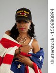 black woman in her grandfathers hat, and wrapped in a US flag, remembering and taking pride in his service to the United States in WW 2