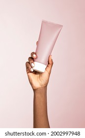 Black woman holding a beauty cream tube