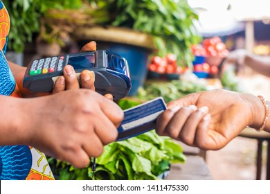 Black Woman Holding A Pos System Collecting A Credit Card From Someone In A Market