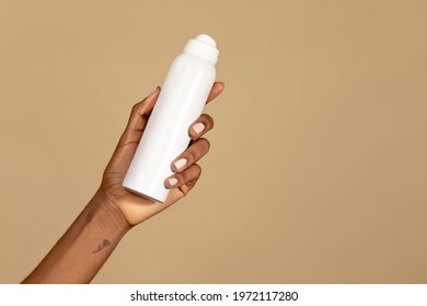 Black woman holding an unlabeled white spray bottle