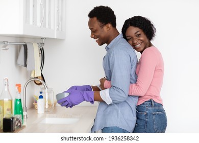 Black Woman Hugging Her Husband Washing Dishes