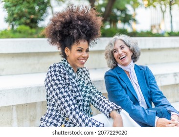 Black Woman Laughing Next To Laughing Mature Woman