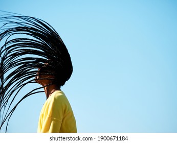 Black Woman With Long Hair And Flying African Braids, Isolated, Blue Sky On The Background, With Copy Space