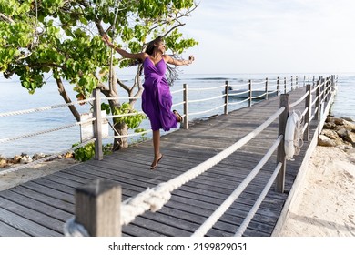 Black Woman With Long Natural Hair Jumps Into The Air In Celebration