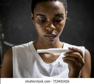 Black Woman Looking At Pregnancy Test 