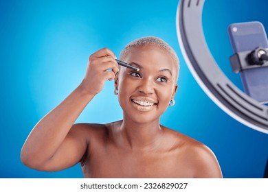 Black woman  makeup   face blogger and eyeliner in studio for beauty  skin glow   shine cosmetics  African female influencer and video tutorial  self care   facial blue background