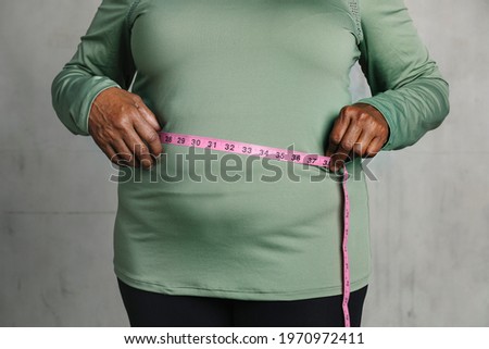 Black woman measuring her tummy