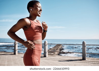 Black woman, music earphone or running by beach, ocean or sea in healthcare wellness or cardiovascular strength. Happy smile, sports runner or listening to workout training or marathon exercise radio - Powered by Shutterstock