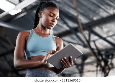 Black woman, planning or personal trainer with a tablet for fitness training, workout or sports exercise. Progress results, digital technology app or gym instructor typing an online coaching schedule - Powered by Shutterstock