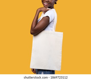 Black Woman Posing With Textile Shopper Eco Bag Standing On Yellow Background In Studio. Fashion And Consumerism. Stop Using Plastic Concept. Shopping And Ecology. Cropped, Mockup - Powered by Shutterstock