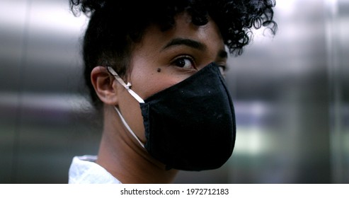 Black Woman Putting Covid-19 Face Mask Inside Elevator