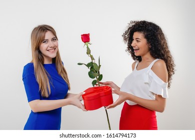 Black Woman Receiving Heart Shaped Valentine Gift And Rose From Girlfriend Isolated On White